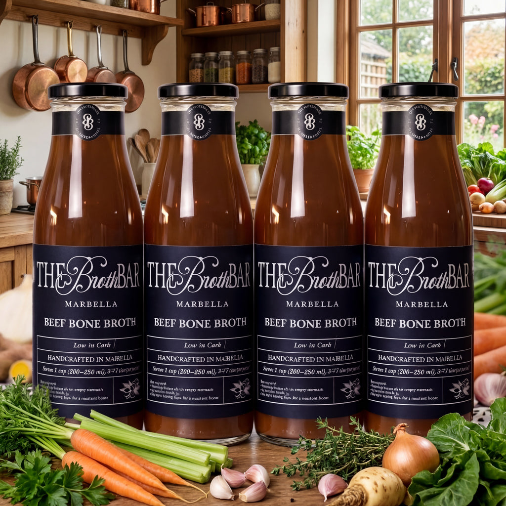 Four bottles of The Broth Bar beef bone broth on a kitchen counter with vegetables.